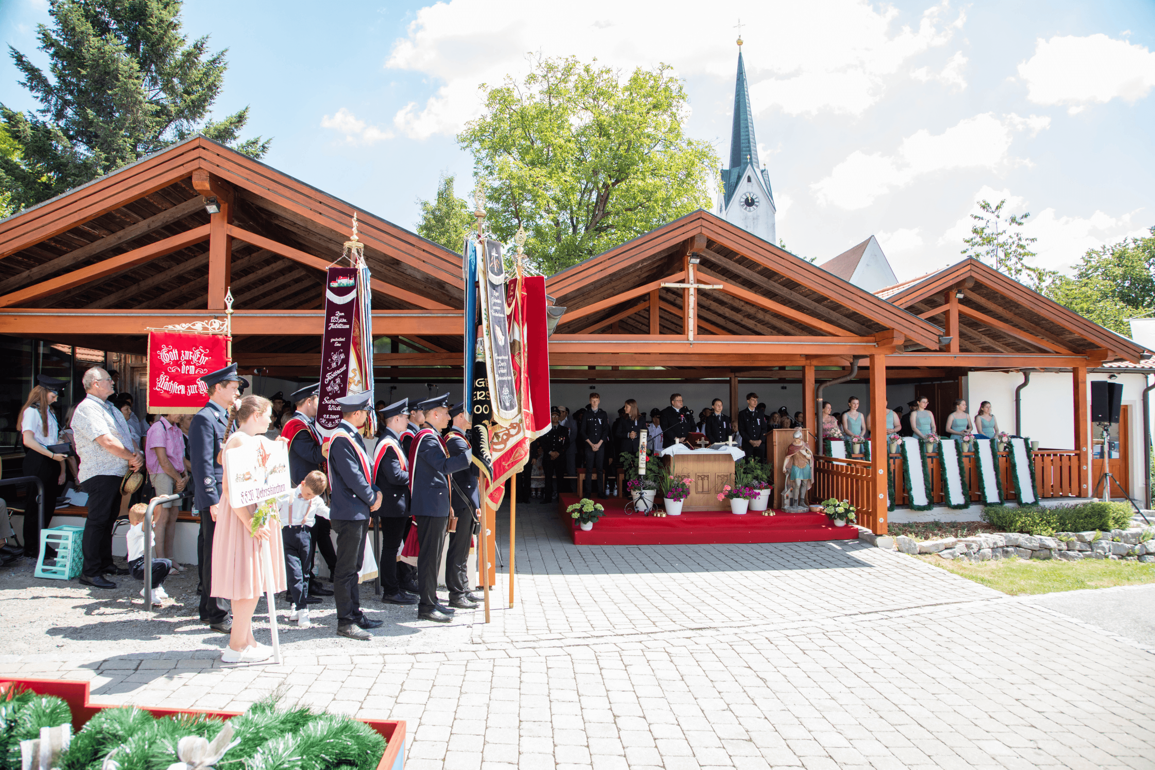 Fahnenabordnungen befreundeter Vereine beim Festgottesdienst vor der Kirche Peterskirchen